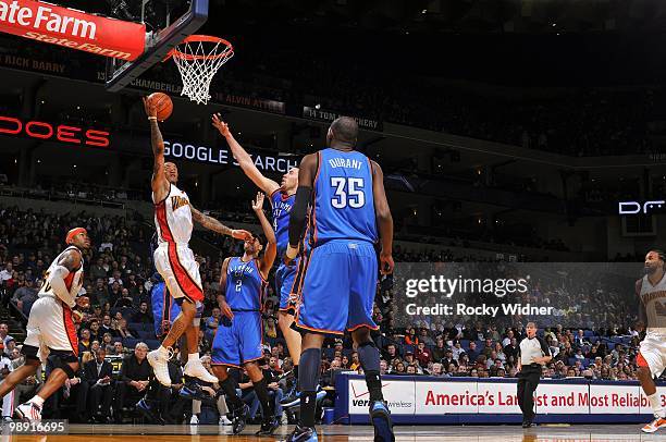 Monta Ellis of the Golden State Warriors shoots a layup against Thabo Sefolosha, Nick Collison and Kevin Durant of the Oklahoma City Thunder during...