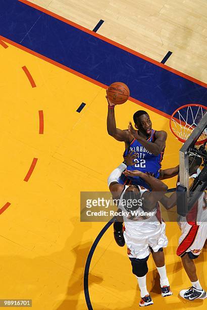 Jeff Green of the Oklahoma City Thunder goes up for a shot against Ronny Turiaf and Reggie Williams of the Golden State Warriors during the game at...