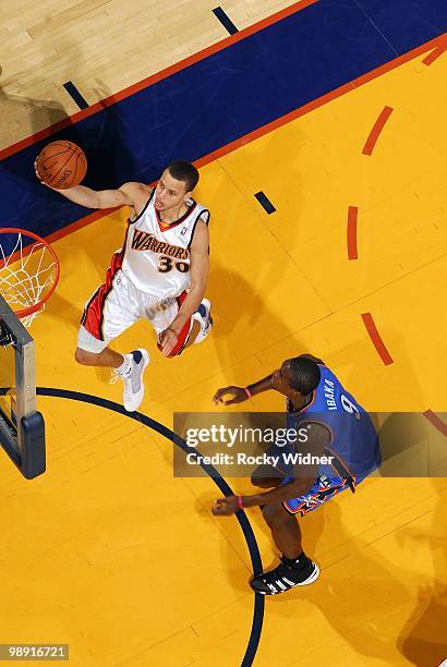 Stephen Curry of the Golden State Warriors shoots a layup against Serge Ibaka of the Oklahoma City Thunder during the game at Oracle Arena on April...