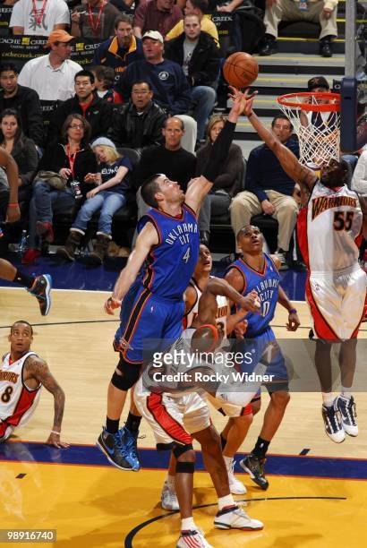 Nick Collison of the Oklahoma City Thunder goes up for a rebound against Corey Maggette, Stephen Curry and Reggie Williams of the Golden State...
