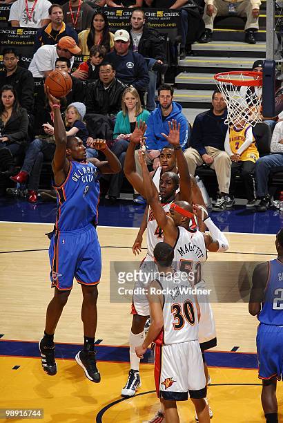 Serge Ibaka of the Oklahoma City Thunder goes up for a shot against Corey Maggette, Anthony Tolliver and Stephen Curry of the Golden State Warriors...