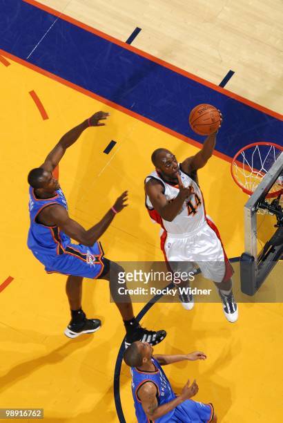 Anthony Tolliver of the Golden State Warriors shoots a layup against Serge Ibaka and Eric Maynor of the Oklahoma City Thunder during the game at...