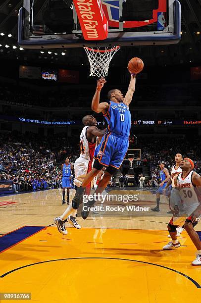 Russell Westbrook of the Oklahoma City Thunder rebounds against Anthony Tolliver and Corey Maggette of the Golden State Warriors during the game at...