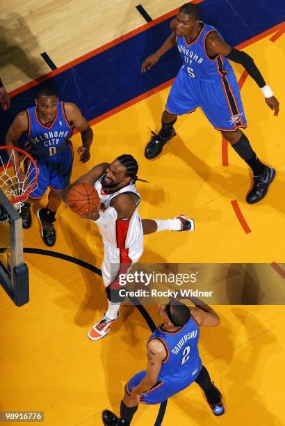 Ronny Turiaf of the Golden State Warriors shoots a layup against Russell Westbrook and Thabo Sefolosha of the Oklahoma City Thunder during the game...