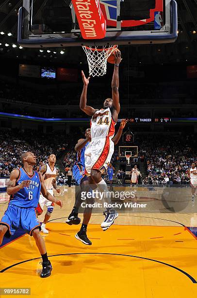 Anthony Tolliver of the Golden State Warriors shoots a layup against Serge Ibaka and Eric Maynor of the Oklahoma City Thunder during the game at...