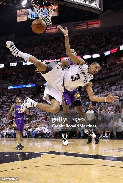 Guard George Hill of the San Antonio Spurs is fouled by Channing Frye of the Phoenix Suns in Game Three of the Western Conference Semifinals during...