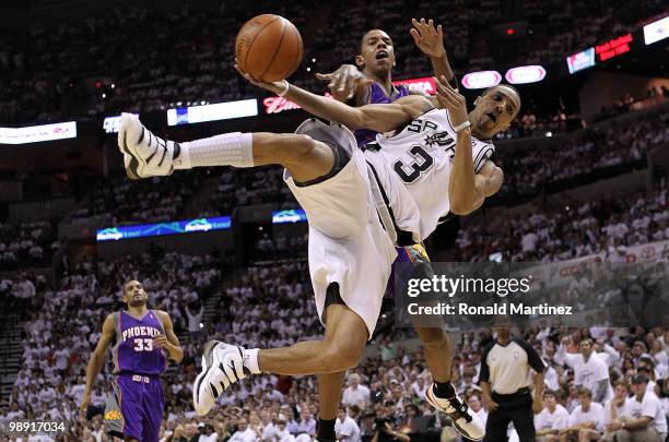 Guard George Hill of the San Antonio Spurs is fouled by Channing Frye of the Phoenix Suns in Game Three of the Western Conference Semifinals during...