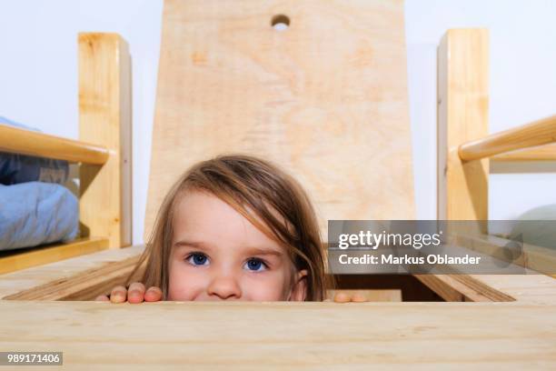 girl, 3 years, looking through a hatch - 2 3 years one girl only stock-fotos und bilder