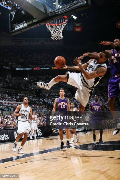 George Hill of the San Antonio Spurs drives to the basket and is fouled by Channing Frye of the Phoenix Suns in Game Three of the Western Conference...