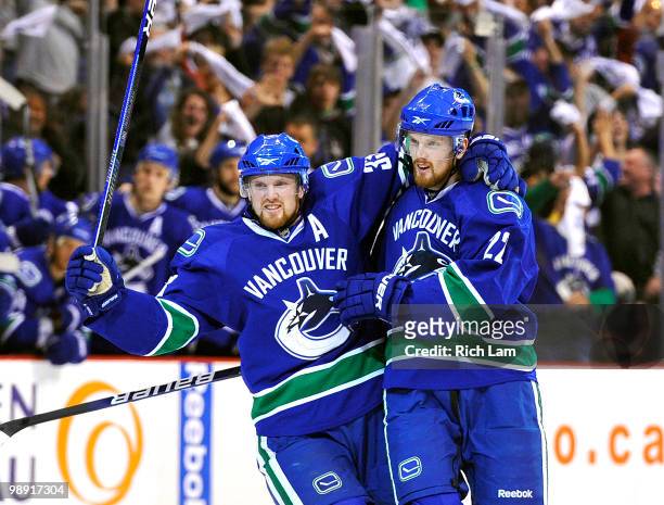 Daniel Sedin and Henrik Sedin of the Vancouver Canucks celebrate after Daniel Sedin scored against the Chicago Blackhawks during the first period in...