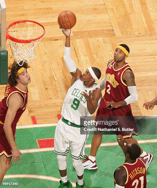 Rajon Rondo of the Boston Celtics shoots against Anderson Varejao and Mo Williams of the Cleveland Cavaliers as Glen Davis looks on in Game Three of...