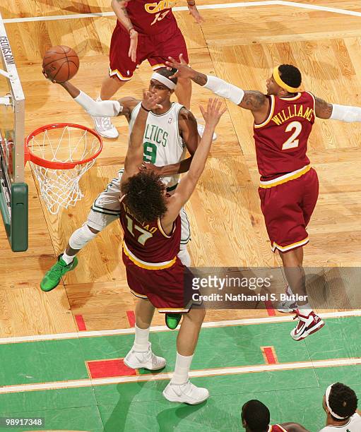 Rajon Rondo of the Boston Celtics shoots against Anderson Varejao and Mo Williams of the Cleveland Cavaliers in Game Three of the Eastern Conference...