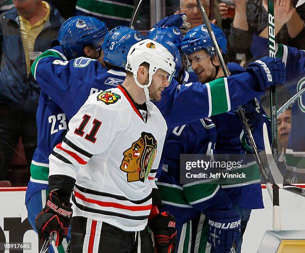 John Madden of the Chicago Blackhawks skates by dejected as the Vancouver Canucks celebrate after scoring in first period action in Game Four in the...