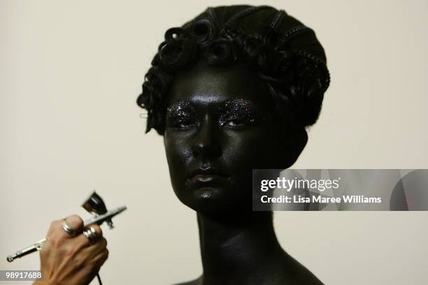 Model is spray painted black backstage at the Romance Was Born collection show at the University of Sydney during Rosemount Australian Fashion Week...