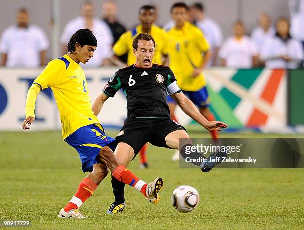 Miguel Ibarra of Ecuador kicks the ball away from Gerardo Torrado of Mexico during the FMF U.S. Tour at the New Meadowlands Stadium on May 7, 2010 in...