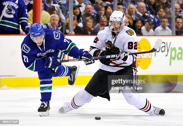 Mason Raymond of the Vancouver Canucks hooks down Tomas Kopecky of the Chicago Blackhawks during the second period in Game Four of the Western...