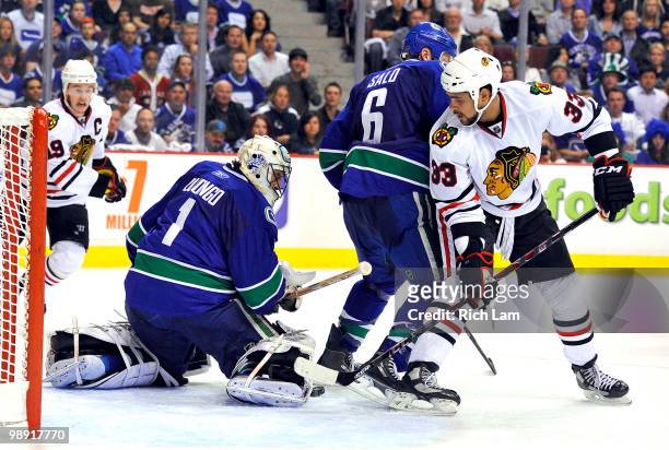 Dustin Byfuglien of the Chicago Blackhawks looks for the loose puck after goalie Roberto Luongo of the Vancouver Canucks made a save while Sami Salo...