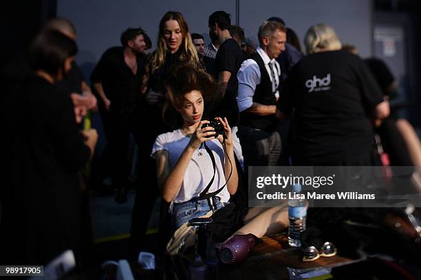 Model Alexandra Agoston takes a photograph backstage at Alex Perry's 'Arabian Princess' show at Fox Studios during Rosemount Australian Fashion Week...