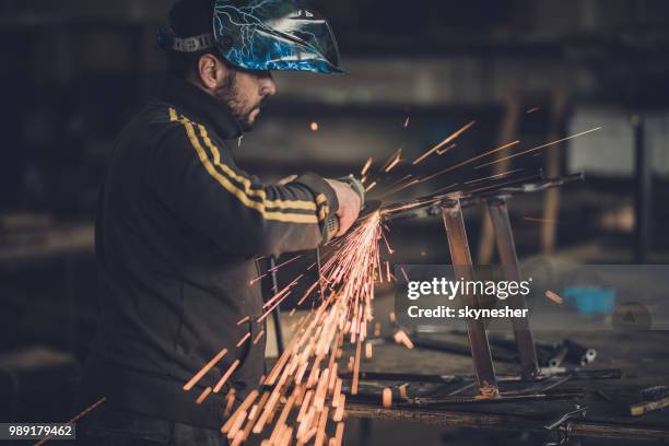 arbeider in een fabriek te werken terwijl het lassen van een strijkijzer met hand zag. - slepen met kabel stockfoto's en -beelden