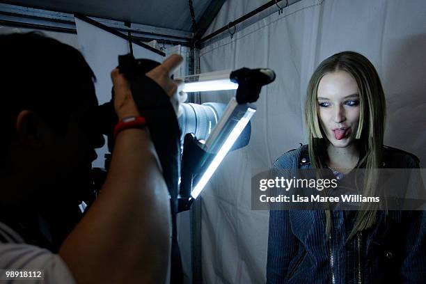 Fashion photographer Wendell Teodoro photographs a model backstage ahead of the Ksubi collection show at the Royal Hall of Industries during...