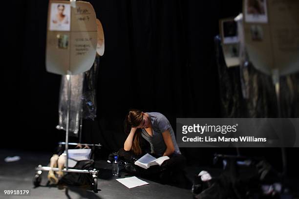 Model sits amongst clothing racks backstage at Alex Perry's 'Arabian Princess' show at Fox Studios during Rosemount Australian Fashion Week...