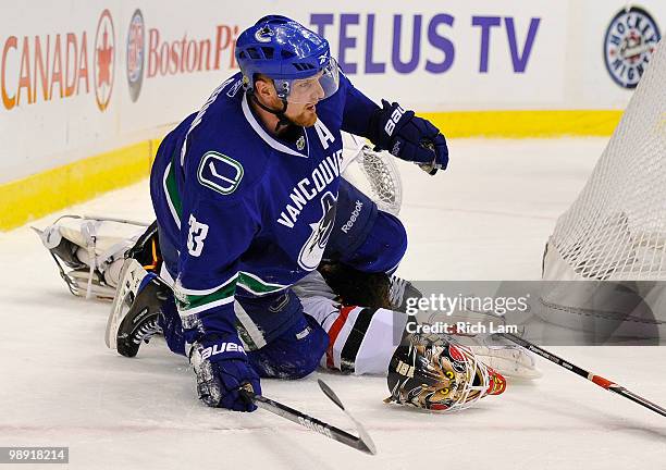 Henrik Sedin of the Vancouver Canucks picks himself up off the ice after colliding with goalie Antti Niemi of the Chicago Blackhawks during the third...