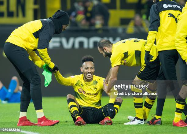 Dortmund's Dan-Axel Zagadou and Oemer Toprak help up the laughing Pierre-Emerick Aubameyang during the German Bundesliga soccer match between...