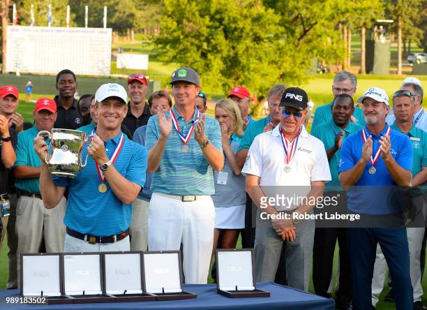 David Toms lifts the winner's trophy as Tim Patrovic, Miguel Angel Jimenez of Spain and Jerry Kelly look on during the final round of the U.S. Senior...