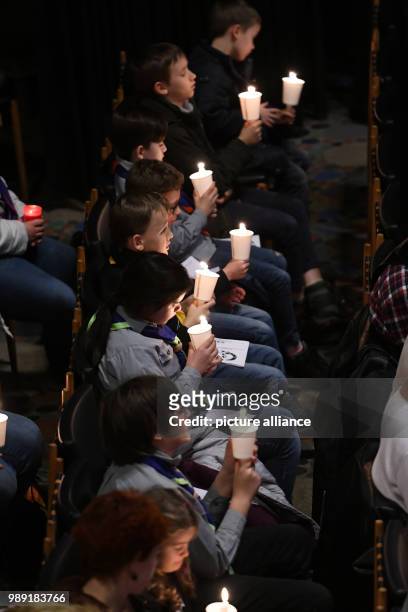 Church-gooers holding Bethlehem's light of peace as a sign against terrorism and violence in the Kaiser Wilhelm Memorial Church in Berlin, Germany,...