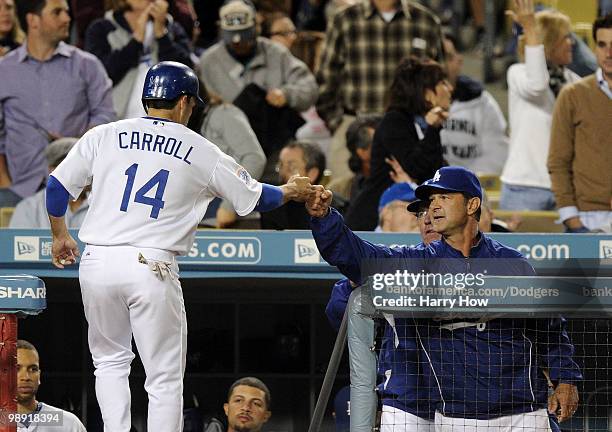 Don Mattingly and Jamey Carroll of the Los Angeles Dodgers celebrate a run for a 6-5 lead over the Colorado Rockies during the sixth inning at Dodger...