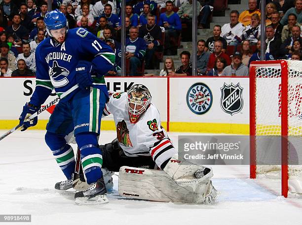 Ryan Kesler of the Vancouver Canucks looks on as Antti Niemi of the Chicago Blackhawks makes a glove save in Game Four of the Western Conference...