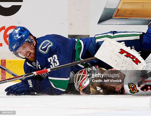 Henrik Sedin of the Vancouver Canucks collides with Antti Niemi of the Chicago Blackhawks in Game Four of the Western Conference Semifinals during...