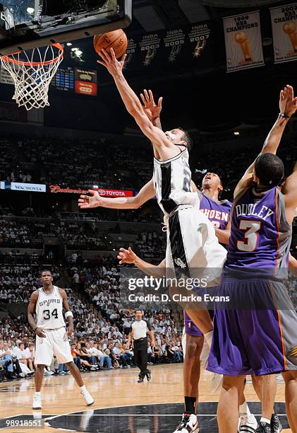 Manu Ginobili of the San Antonio Spurs shoots against Channing Frye and Jared Dudley of the Phoenix Suns in Game Three of the Western Conference...