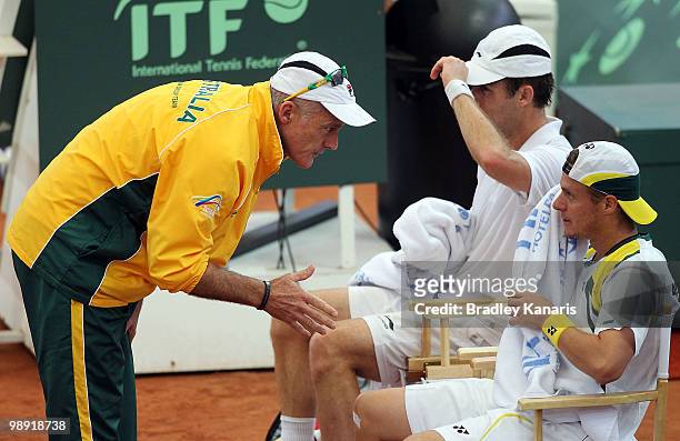Team captain John Fitzgerald speaks with Lleyton Hewitt and Paul Hanley of Australia during their doubles match against Go Soeda and Takao Suzuki of...