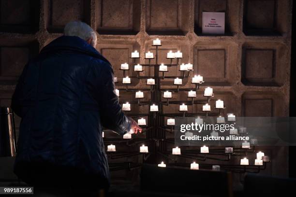 Churchgoer light candles with flames from the city of Bethlehem, known as the Peace Light of Bethlehem, as a sign against terrorism and violence at...