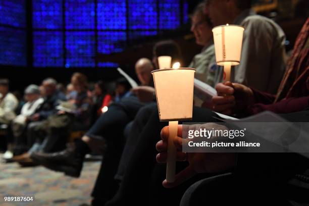 Church-goers holding Bethlehem's light of peace as a sign against terrorism and violence in the Kaiser Wilhelm Memorial Church in Berlin, Germany, 17...