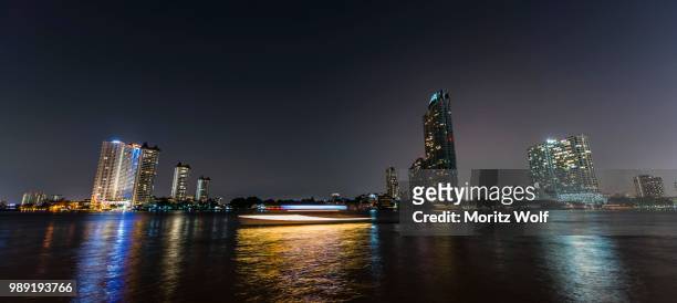 skyline and boat on the river mae nam chao phraya, at night, bangkok, thailand - river chao phraya bildbanksfoton och bilder