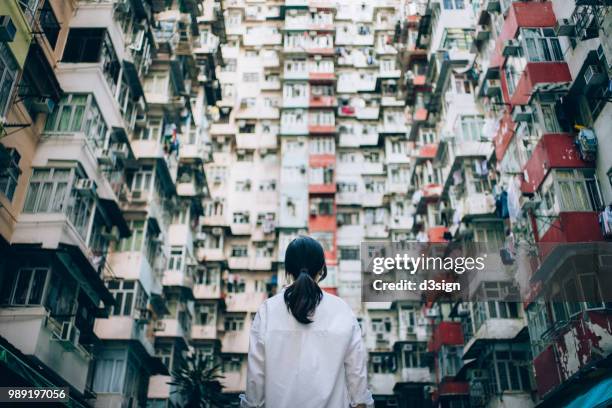 rear view of woman surrounded by old traditional residential buildings and lost in city - solo 2018 film foto e immagini stock