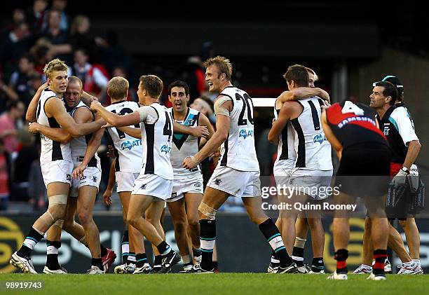 Jackson Trengove of the Power is hugged by team-mates as Jobe Watson of the Bombers looks dejected as the Power win the round seven AFL match between...