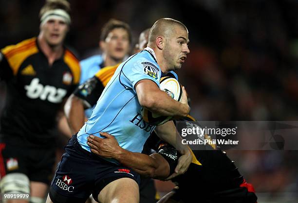 Drew Mitchell of the Waratahs is tackled by Tanerau Latimer of the Chiefs during the round 13 Super 14 match between the Chiefs and the Waratahs at...