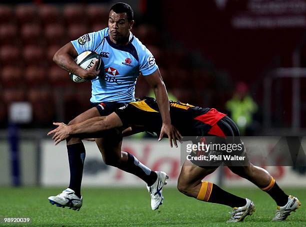 Kurtley Beale of the Waratahs is tackled by Jackson Willison of the Chiefs during the round 13 Super 14 match between the Chiefs and the Waratahs at...