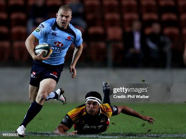 Drew Mitchell of the Waratahs escapes the tackle of Tanerau Latimer of the Chiefs during the round 13 Super 14 match between the Chiefs and the...