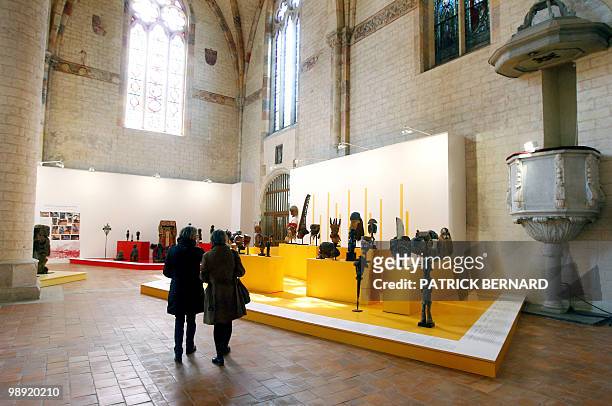 People look at masks and sculptures displayed during an exhibition on "Africa, Arts and Traditions from profane to sacred", on May 7 at the Jacobins...