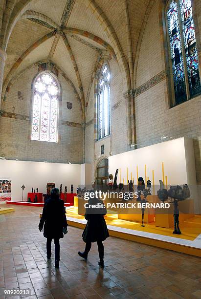 People look at masks and sculptures displayed during an exhibition on "Africa, Arts and Traditions from profane to sacred", on May 7 at the Jacobins...