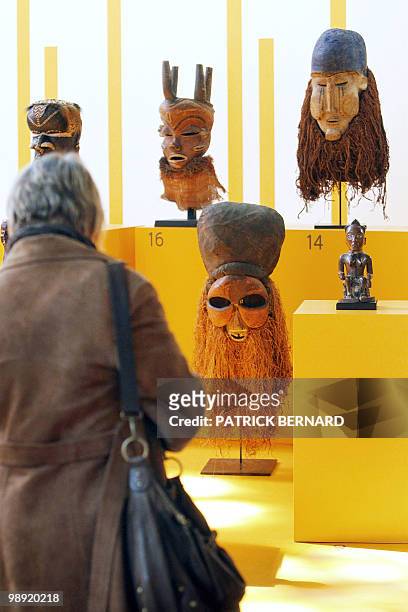 Person looks at masks displayed during an exhibition on "Africa, Arts and Traditions from profane to sacred", on May 7 at the Jacobins church in...
