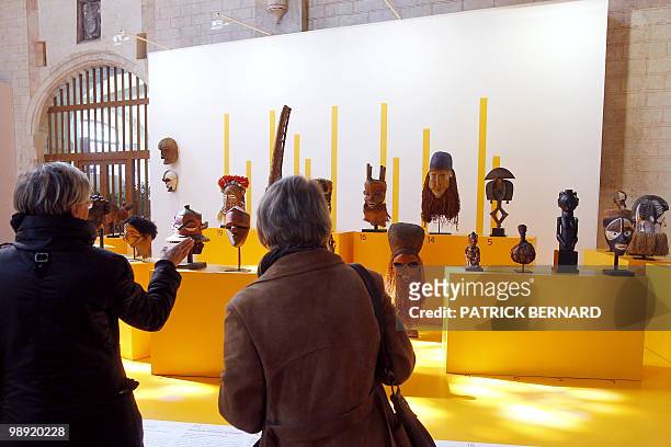 People look at masks and sculptures displayed during an exhibition on "Africa, Arts and Traditions from profane to sacred", on May 7 at the Jacobins...