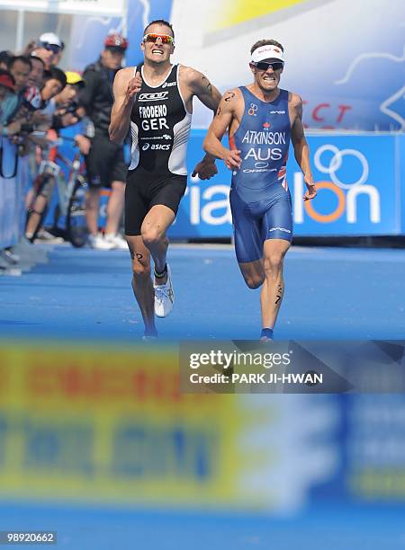 Germany's Jan Frodeno and Australian Courtney Atkinson run side by side for the finish line during the 10km run leg of the men's event at the Seoul...