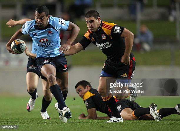 Kurtley Beale of the Waratahs breaks through the tackle of Dwayne Sweeney and Richard Kahui of the Chiefs during the round 13 Super 14 match between...