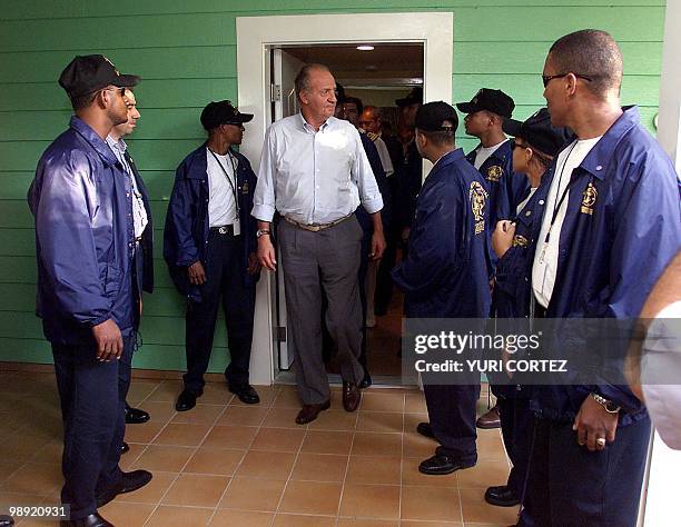 Security stands with King Juan Carlos of Spain as he emerges from a meeting during the XII Ibero-American summit 15 November 2002 in Punta Cana,...