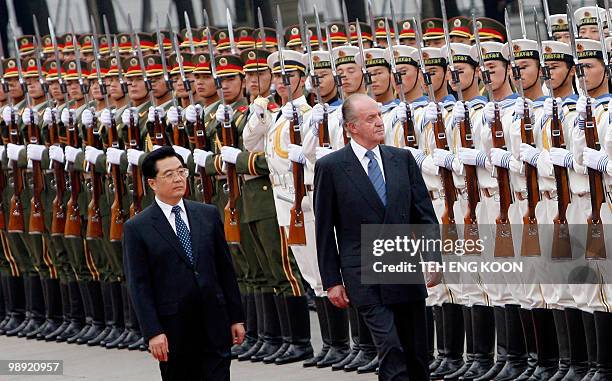 Visiting Spanish King Juan Carlos I walks with his Chinese counterpart Hu Jintao as they inspect the guard of honor during a welcoming ceremony at...